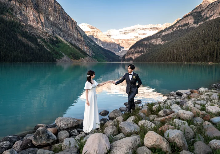 Groom holds the bride's hand with the elegance.