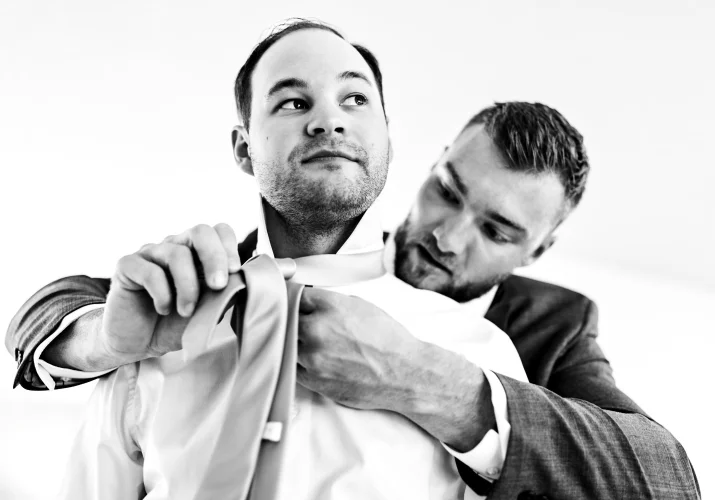 Best mes helps the groom with the tie.