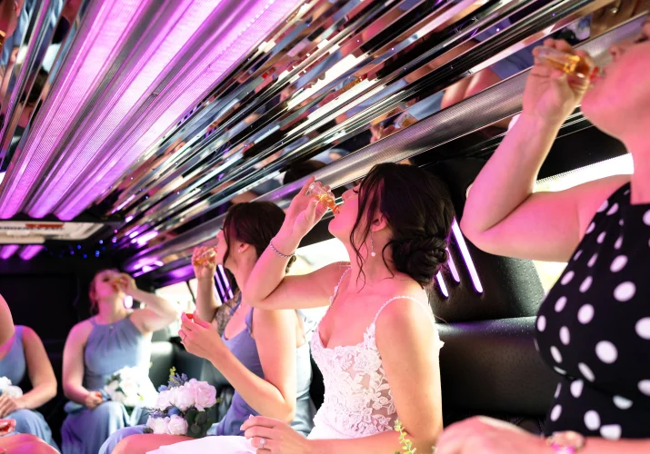 Bridal party drinking shoots in the limo on the way to Calgary Wedding Ceremony.