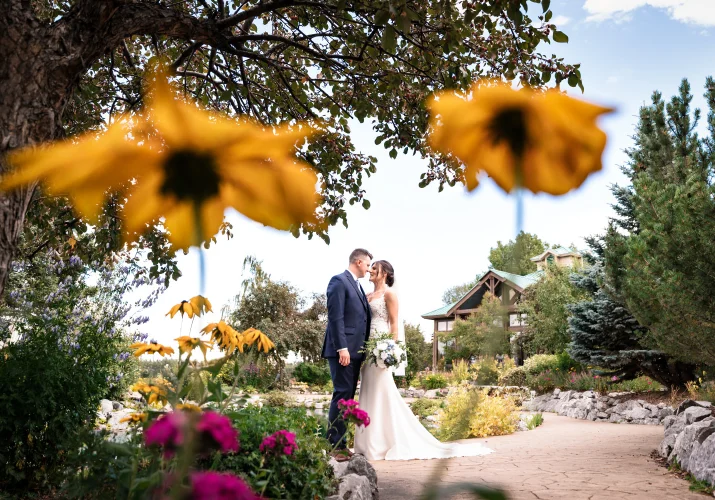 Photograph of the newlyweds in between the yellow flowers.
