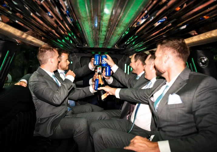 Wedding party in the limo drinking beers.