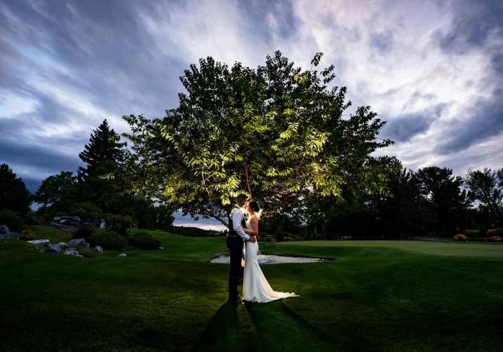 Fantastic portrait of the bride and groom facing each other under the tree