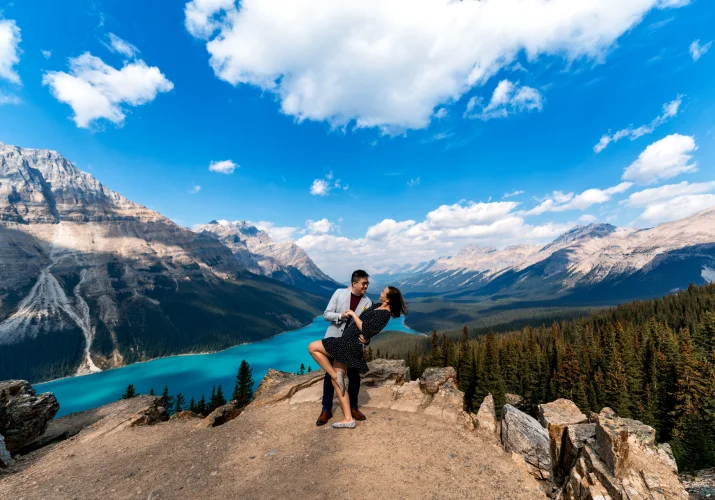 Engaged couple in love dance at Payto Lake against Rocky Mountains.