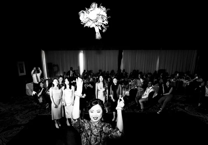 Bouquet tossing while all the single ladies try to catch the flowers during banff wedding reception.