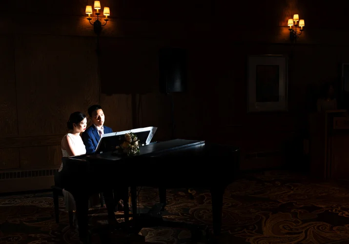 Bride and groom give a piano performance on they wedding reception in banff