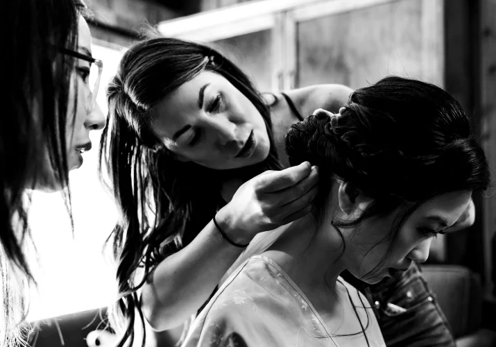 banff make up artists work on the bride's hair. Moment in black and white captured by Banff Wedding Photographers.