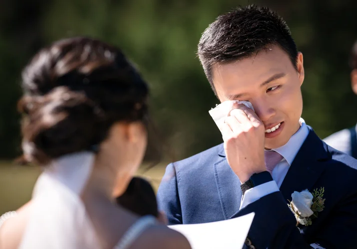 the groom wipes his tears during touching bride's speech at the banff wedding ceremony.