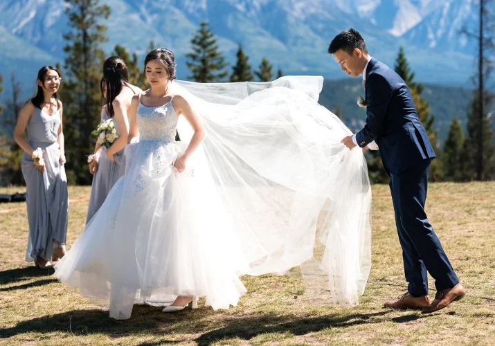 the groom fixed the bride's huge, white wedding dress