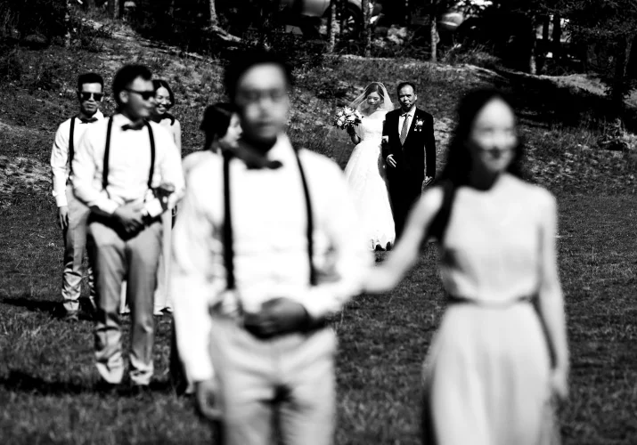 Wedding party and bride and groom walk on the aisle at the wedding ceremony at Tunnel Mountain in Banff. Photograph in black and white taken by Banff Wedding Photographer.