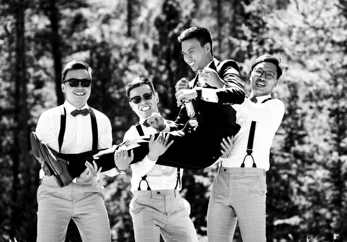 Funny Banff Wedding Photograph of the wedding party lifting the groom on their hands.