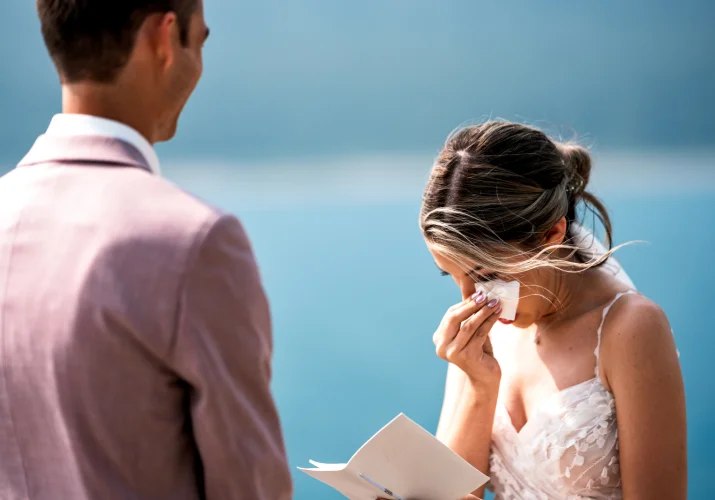 Bride wipe her chick as she cries during reading the vows. Emotional moment captured by Banff Wedding Photographer.