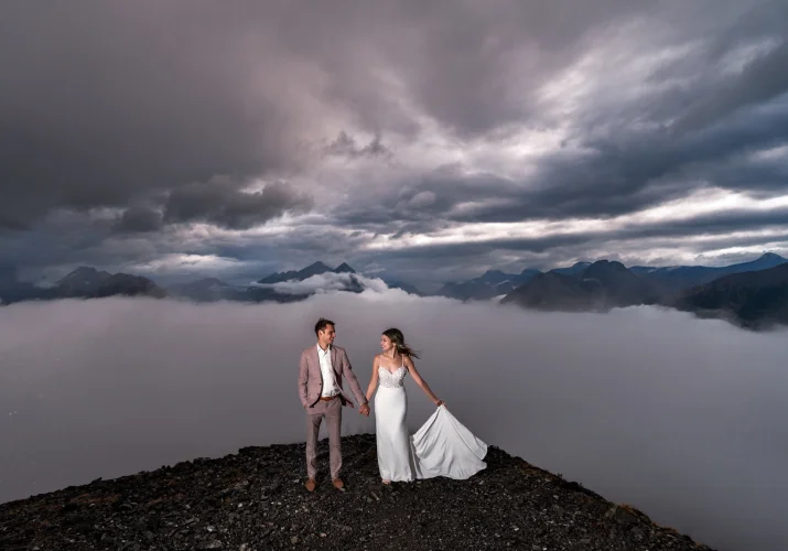 Wedding photography in Banff, showcasing the beauty of the Canadian Rockies and capturing precious moments of the bride and groom holding hands and looking into each others eyes.