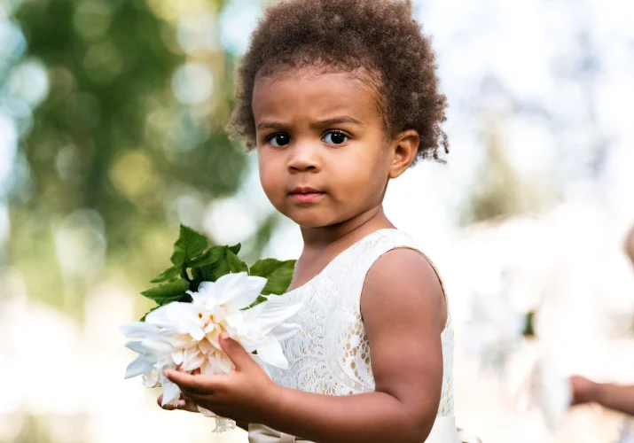 Flowergirl holding the white flower.