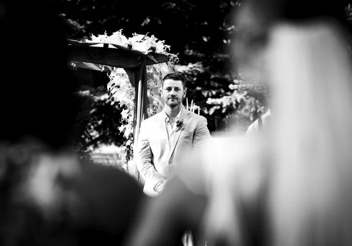 Groom look at the bride while she is walkin down the aisle.