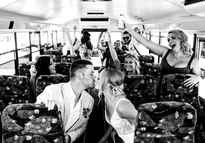 Bride and groom share a kiss in the bus.
