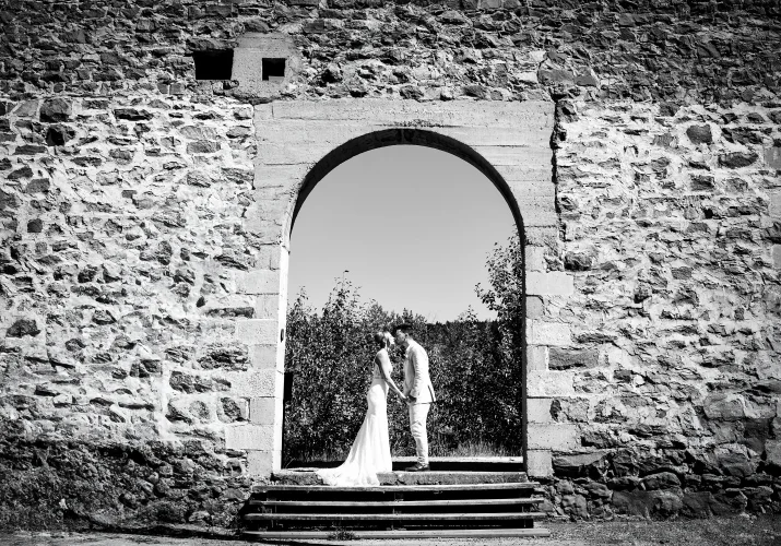 Bride and groom share a kiss in the ols, brick building.