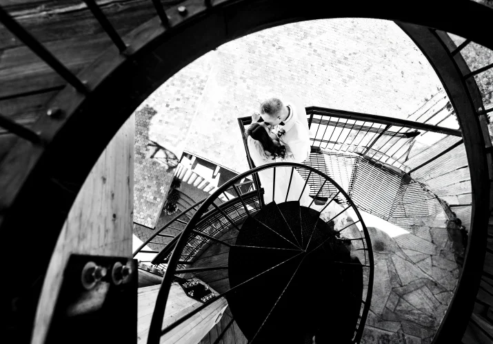 Bride and groom share a kiss on the stairs in Calgary