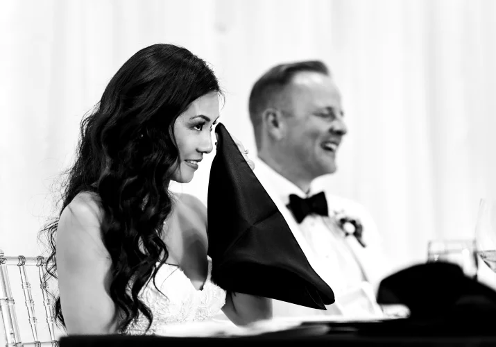 The bride wipes her cheek as she cries during the wedding speaches