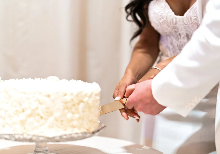 Calgary Wedding Detail Photography of the newlyweds cutting the wedding cake
