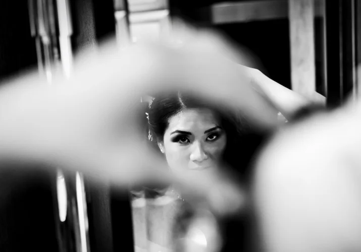 Black and white photography of the bride fixing her hair