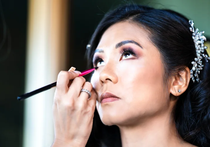 Bride is getting fer make up done before Calgary Wedding Ceremony
