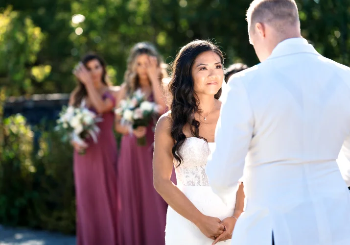 Bride look at the groom with love. Bride maids cry behind