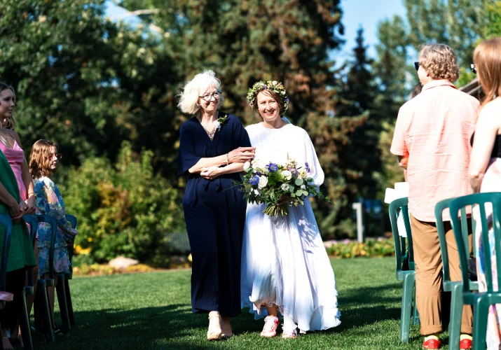 Mather of the bride walks the bride down the aisle.