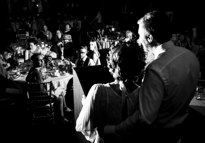 Calgary Wedding Photography of the bride end groom giving a speech. All the guests are listening.