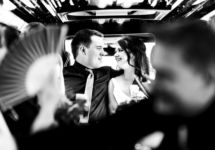 Newlyweds look at each other in the limo