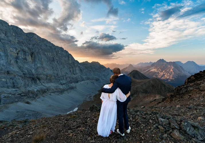 Bride and groom in a hug looking at the stunning sunset in the Canadian Rockies