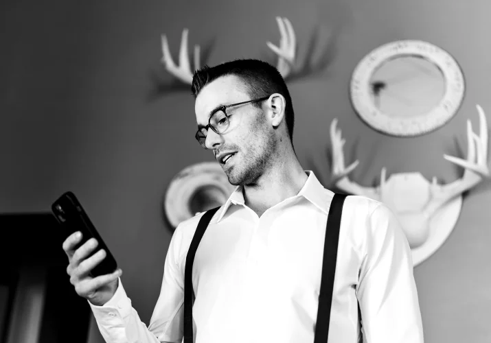 A man check time on hiss cellphone to be on time for the wedding ceremony.