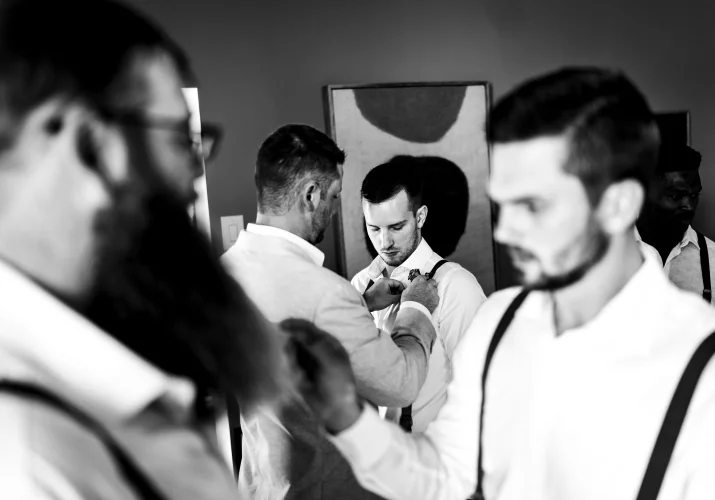 Gentelmen get ready for thr Waterton wedding. They fix their ties.
