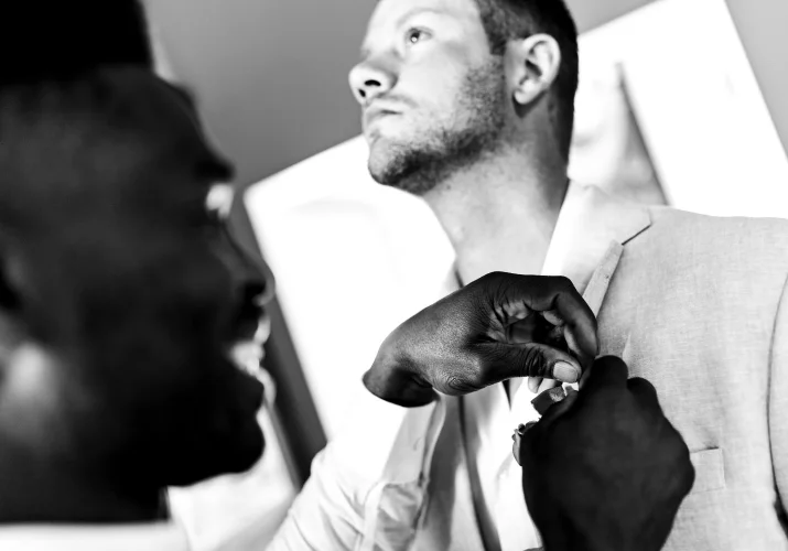Best men put a flower on the grooms vest.