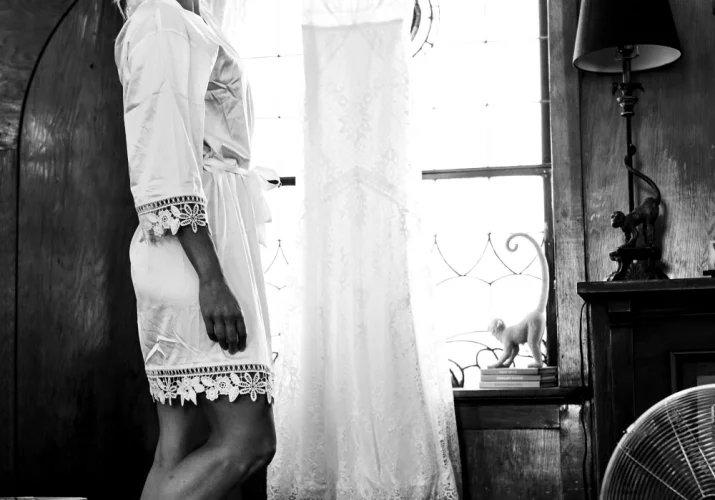 Bride reaches for her wedding dress before getting ready.