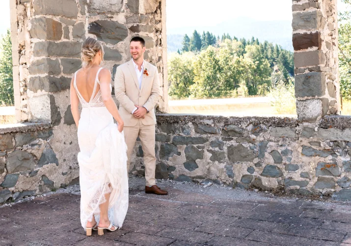 First look of the groom on the bride. He's smiling while she's walkin to him.