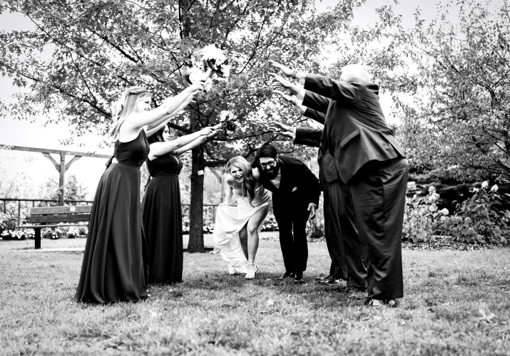 Newlyweds run under the hand bridge created by wedding party in Edmonton