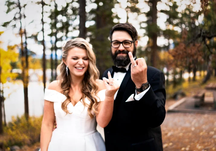Bride and groom point their fingers with the wedding rings