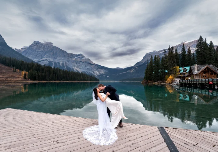 Wedding dip of the bride and groom at Emerald Lake .