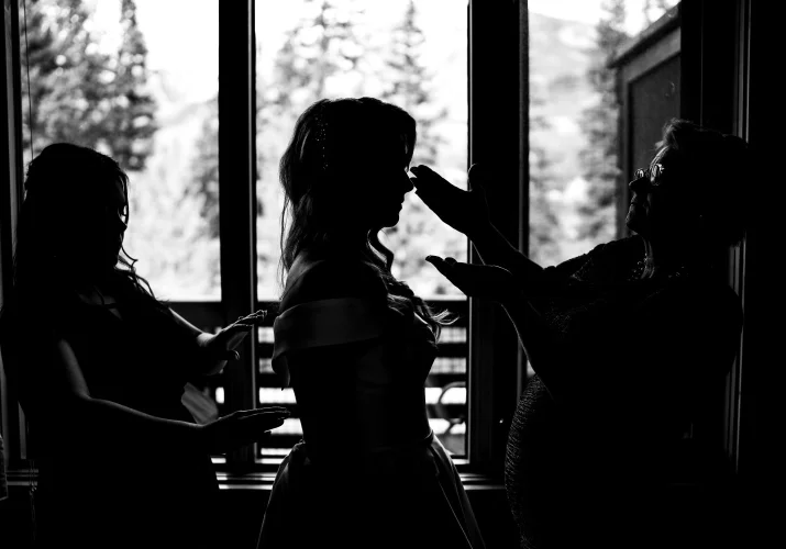 Banff Wedding Photography of the bride and her sister an Mather putting the dress on