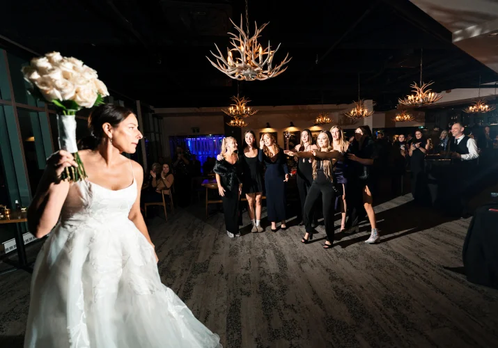 The bride troughs the bouquet while single ladies try to catch it