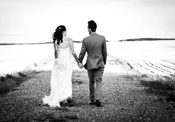 Newlyweds walk and hold hands at the canadian farm