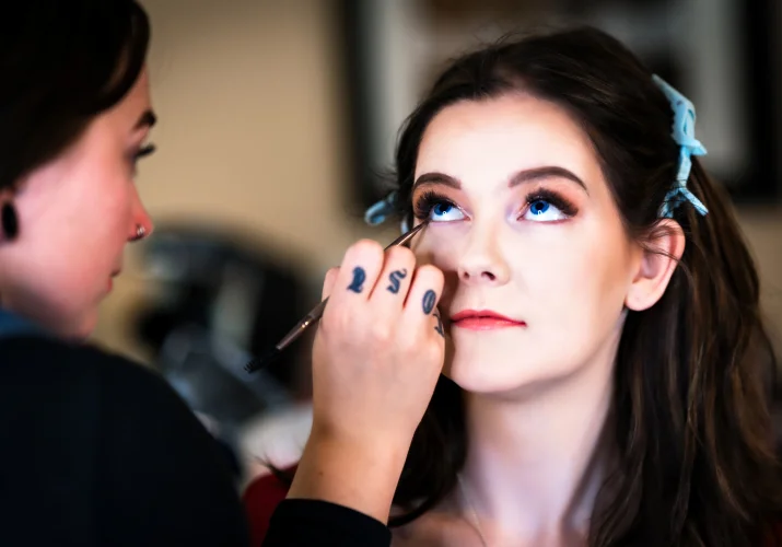 The bride is getting a make up done before the wedding ceremony in Calgary