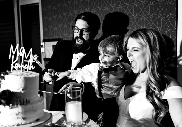 Bride, groom and their son cutting the wedding cake in Edmonton.