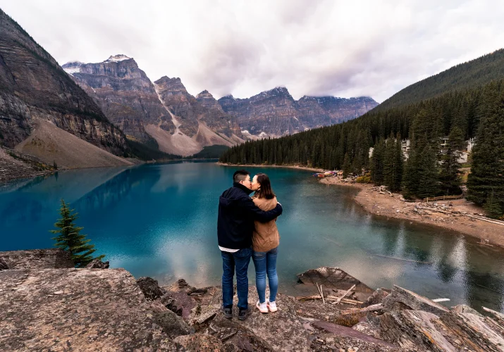 Couple in love adore the view of blue water at Moraine Lake