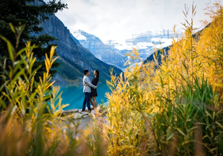 Shoot through yellow grass of the couple in a hug
