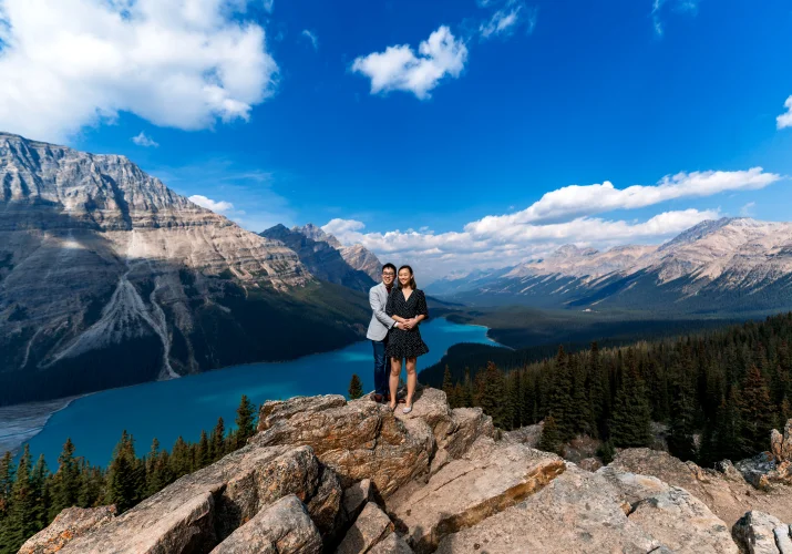 Men hugs his fiance from behind at blue peyto lake in Banff National Park