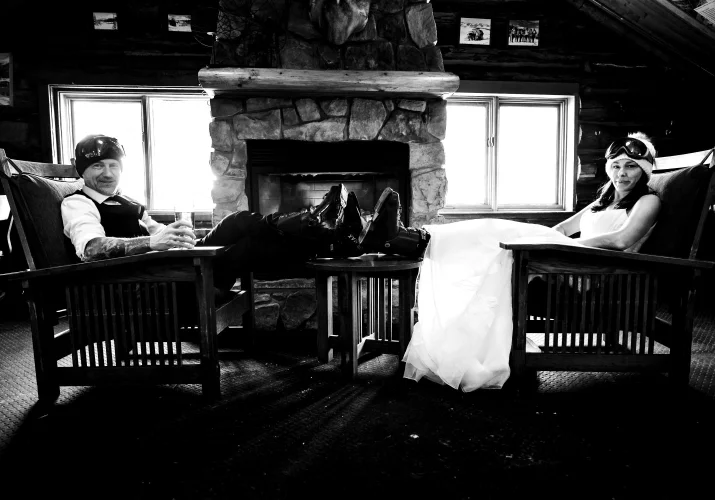 Bride and groom take break after long skiing day with their legs on the coffee table.