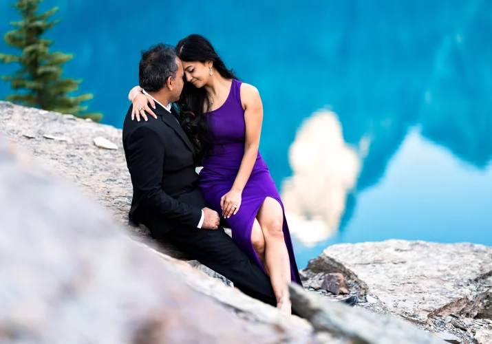 Lady in a purple dress sitting at her husband lap.