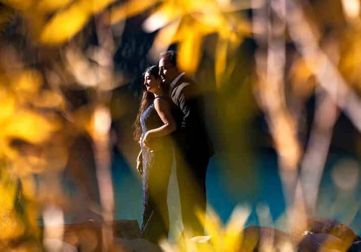 husband holds his wife from behind during fall at Lake Louise