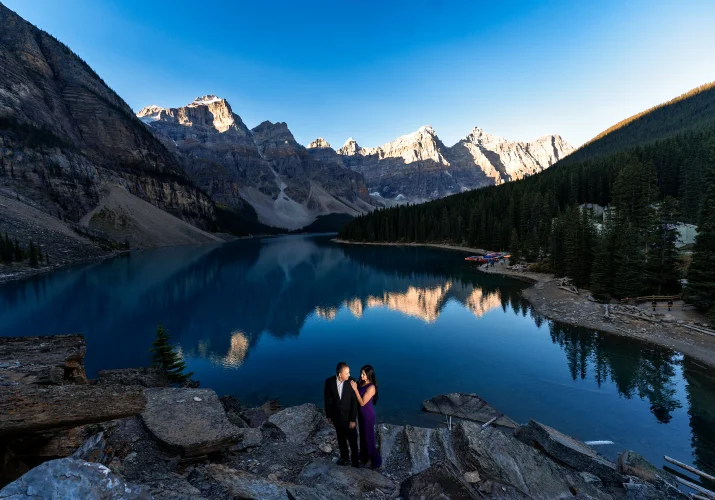Anniversary Photo Session at Moraine Lake of the couple in love standing on the huge rocks.